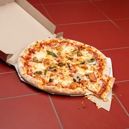 A pizza that fell on the red tiled floor