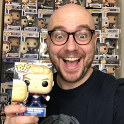 a happy nerdy balding guy showing his collection of funko pop, big open smile, a funko pop of captain marvel in his hands, realistic, selfie