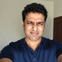 Indian dad talking a selfie squinting because the flash is so bright