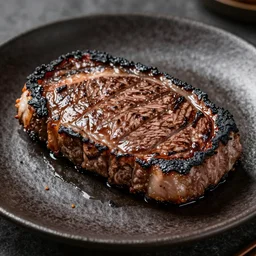 wagyu steak completely burned, charcoal crust on a plate