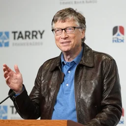 Bill Gates giving a press conference while wearing a leather jacket