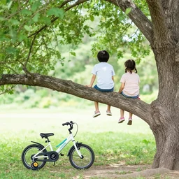 two kids sitting in a tree branch, with a bicicle near the tree