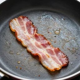 bacon being cooked fried, it looks like a face