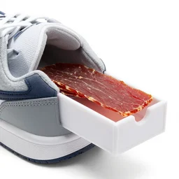 sports shoe with built - in attached small sliding drawer open, slice of jerky inside, product photo