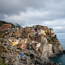 award winning landscape photography of impossibly tall cliffs with a seaside town dangling from ornate concentric castles nd rock formation. epic sky. trending.
