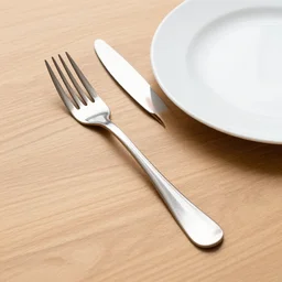 a fork, a plate and a knife on a wooden table