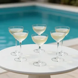 5 5 mm photo of best two long cocktail glasses on a zen minimalist white table with gorgeous pool in the background. highly detailed 8 k. intricate. lifelike. soft light,