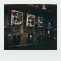 a dark gift shop with bungie halo toy boxes hung up on a shelf. 3 5 mm f / 2. 8 macro lens. creepy dark polaroid.