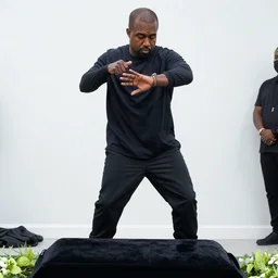 photograph of kanye west at a funeral, dancing