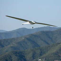 glider soaring over mountain