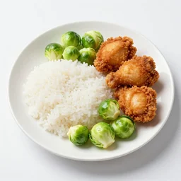 a plate of white rice Brussels sprouts and fried chicken