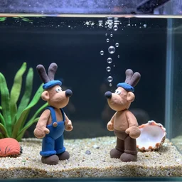plasticine models. side view of tropical fish tank with sand and gravel, wallace and gromit, wrong trousers. figures clay. water. aquatic photography. bubbles out of a shell