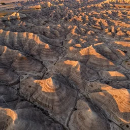 aerial overhead drone shot of badlands ground in golden hour lighting