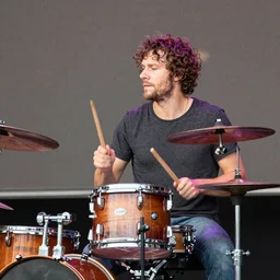 a man plays a drum solo on stage at Woodstock, award winning