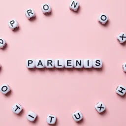 pink solid background with letter beads scattered around the edges and in the center letter beads spelling out parlenis