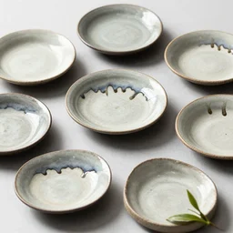 a set of japanese handmade plates, drips, dripping glaze, glazed clay, crazed glaze glaze drips, artistic, exquisite, tea leaves, zen,