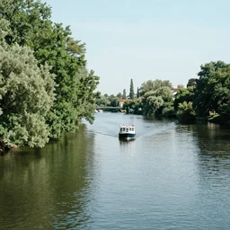 'a boat in a river with trees alongside'