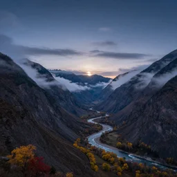 Panoramic photo where the mountains are towering over the valley below their peaks shrouded in mist. The moon is just peeking over the horizon and the sky is covered with stars and clouds. The river is winding its way through the valley and the trees are starting to turn yellow and red