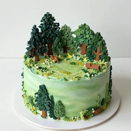 a cake with an intricate forest scene on top made out of icing