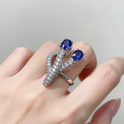 Snake-shaped ring twisted on finger with sapphire eyes and diamond-covered body
