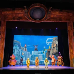 photo of a huge theaterstage, play is ice age, 3 actors on stage, 8 k, multicolored, exaggerated detailed, long shot