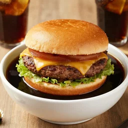 a juicy hamburger in a giant bowl filled with coke