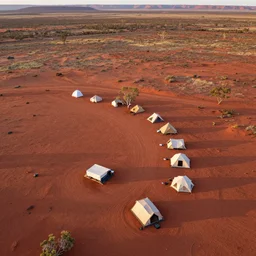 aerial drone photograph of a campsite on the border of the australian red desert