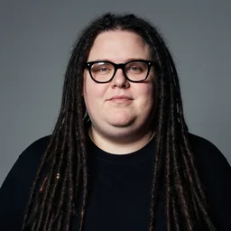 a beautiful portrait of an obese white skinned entrepreneur with long black dreadlocks and trendy glasses, by annie leibovitz