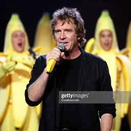 bob geldof boomtown rats holding banana microphone, with banana costumed background singers, concert photo, getty images,