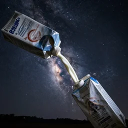 The milky way galaxy being poured out of a milk carton