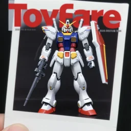 toyfare magazine cover of raven kenku figurine. limited edition. gunpla studio lighting. 3 5 mm f / 2. 8 macro lens. polaroid - w 7 6 8
