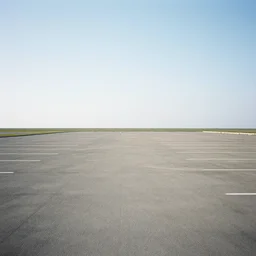 flash photography of a simple, peaceful, unnaturally expansive empty car park that stretches across the whole horizon and land.