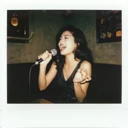 a polaroid photograph taken by nobuyoshi araki of a beautiful woman with an ecstatic smile singing passionately in a karaoke bar in tokyo 1 9 7 8