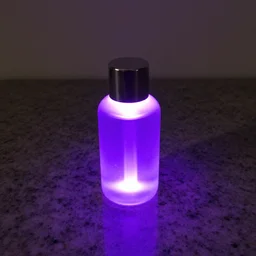 glowing liquid filled bottle on granite tabletop, lit by purple blacklight, sigma 8 5 mm f / 1. 4