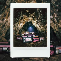 instax polaroid film photo of a cave full of barbie VHS tapes, faded glow, expired film analog photography