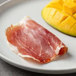 A slice of prosciutto squished with mango and raw fish