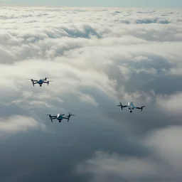 cinematic areal shot of three drones flying through the clouds