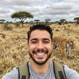 a selfie of a man smiling in the safari with a tiger running up behind him