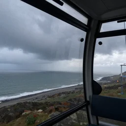 Interior of a cable car, over the English channel, looking out the window, on a rainy stormy day