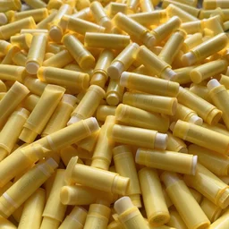 realistic photograph 1 0 0 0 0's of yellow - coloured chapstick tubes in giant piles, high detail, shaded, backlit, glossy, backlit, ultrawide panoramic shot