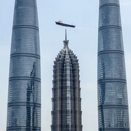 a ship on the air on top of three skyscrapers