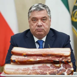 close - up of haunting viktor orban sitting behind a table full of bacon
