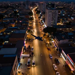 flying drones over a - a neon lit - lagos urban street - in nigeria,