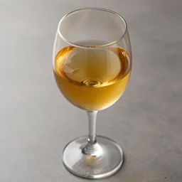 a wine glass filled with gold syrup