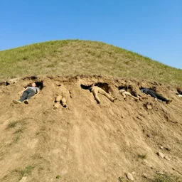 cross section of a hill showing human bodies buried under the hill