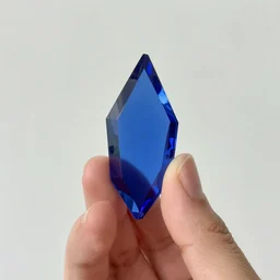 a picture of a hand holding a blue shard of glass
