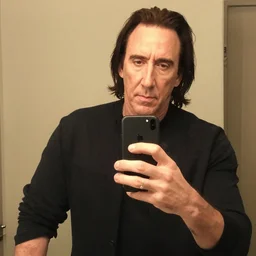 nic cage taking a selfish with himself while he holds the phone for himself