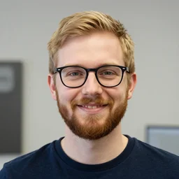 photo of a 3 0 year old male software developer, blonde hair, 3 beard, black rim glasses, friendly