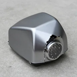 weird angular dented broken plastic  cover chrome underside vented machine on the concrete
