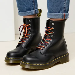 a black leather dr martens boot with rainbow laces
